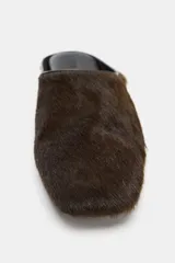 Zapato plano destalonado estilo mule, color marrón, con efecto pelo, punta cuadrada y suela plana.