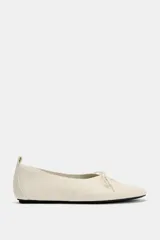 Zapato plano de piel en color blanco roto, con cierre de cordones decorativos en el empeine, punta redonda y tirador trasero.