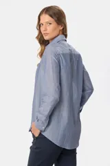 Camisa celeste con rayas verticales blancas, de corte holgado y manga larga.