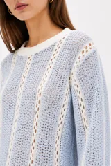 Sweater de algodón de punto con diseño a rayas verticales en color rojo y blanco, cuello redondo y mangas largas.