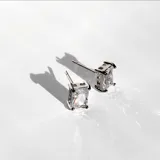 Par de aros plateados con piedra blanca cuadrada.