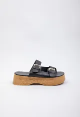Sandalias negras de cuero con plataforma de madera y hebillas metálicas.