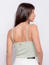 Top color beige al cuerpo sin mangas, con escote en v, tirantes finos y abertura en parte central.