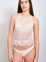 Top de lencería color crema, confeccionado en encaje floral, con cuello halter y corte ajustado.