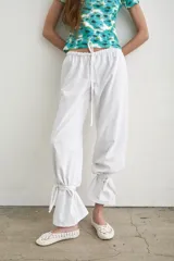 Pantalón recto marrón de lino y algodón, con tiras regulables en los tobillos para ajustar.