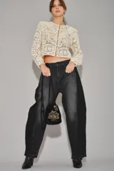 Jean de corte barrel con diseño de pierna curva y holgada, confeccionado en denim negro con efecto lavado. Presenta un estilo moderno y estructurado con costuras laterales marcadas.