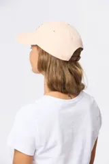 Gorro con visera de lona rosado con bordado frontal en tonos verde y violeta.