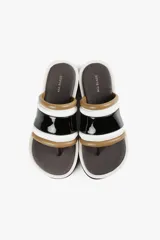 Sandalia con base alta y diseño de líneas audaces. Presenta capellada ancha con acabado brillante y estructura acolchada que aporta confort al andar. La suela dentada le da un carácter urbano y moderno, sin resignar comodidad.