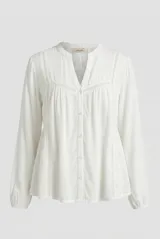 Camisa color natural de manga larga, con escote en V y detalles de encaje o calados decorativos en el frente y las mangas. Cierre frontal con botones.