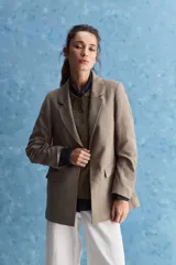 Blazer de corte recto y silueta relajada, de color tostado, con solapas clásicas y bolsillos con solapa en los laterales.