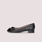 Bailarinas negras de napa acolchada con puntera de charol, lazo negro y tacón de 2.5cm. Suela de goma antideslizante, plantilla de piel y forro de tela.
