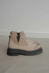 Botas tipo Chelsea de caña corta con diseño bicolor en tonos marrón y negro. Presentan paneles elásticos laterales, puntera reforzada y suela track robusta con plataforma.