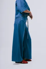 Pantalón wideleg de denim azul oscuro, de tiro alto y corte amplio con bolsillos laterales y cinturón incorporado.