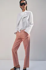 Jeans de tiro medio con diseño de rayas verticales a contraste. Cuenta con cinco bolsillos, trabillas en la cintura y cierre frontal con cremallera y botón.