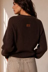 Buzo de tejido de punto celeste, con cuello redondo, mangas largas y diseño holgado.