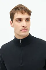 Buzo azul marino de tejido de punto con cuello alto y medio cierre con cremallera.