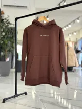 Canguro oversize de color marrón, con capucha y estampa en la espalda con el texto "Official Member of Top Style Club".