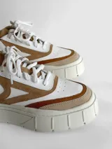 Zapatillas deportivas de cuero color beige, blanco y marrón, con cordones y suela de goma.