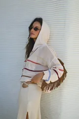 Buzo con capucha de tejido de punto abierto, color blanco roto, de corte oversize y manga larga con detalle de flecos en los puños.