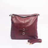 Cartera tipo bolso de color bordó, con textura granulada y detalles de dos correas decorativas con hebillas metálicas doradas en el frente. Cuenta con cierre superior, asa de hombro fija y correa larga ajustable y extraíble.