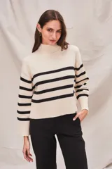 Polera de cuello alto, color blanco con rayas horizontales marrones. De calce ajustado y manga larga con puños acampanados.