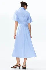 Vestido midi camisero con estampado de rayas verticales celestes y blancas, cuello camisero, botonadura frontal completa, mangas cortas raglán y lazo ajustable en la cintura.