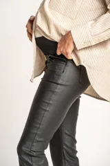 Pantalón negro de corte flare, tiro medio y efecto encerado.