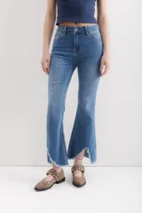 Pantalón jean de corte acampanado, tiro alto, color celeste y terminación desflecada.