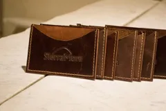 Tarjetero de cuero con diseño animal print en el frente y cuero liso marrón oscuro en la parte posterior, con compartimentos para tarjetas en ambos lados.