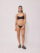 Bombacha de bikini fucsia con tiras laterales regulables para atar en los laterales.