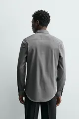 Camisa de hombre color beige claro, de corte slim fit, con cuello italiano, manga larga y cierre frontal de botonadura.