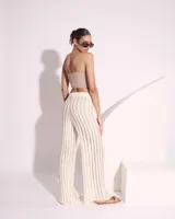 Pantalón de tejido crochet color crema, de corte palazzo y cintura alta.