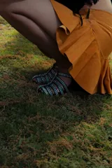 Minifalda de cuero color marrón oscuro, con fajón en la cintura y volados en el ruedo.