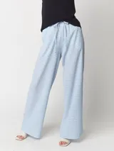 Pantalón palazo a cuadros celestes y blancos, con tiro alto y elástico en la cintura.