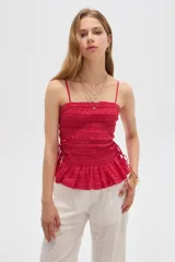 Top de algodón rojo con diseño a cuadros, escote recto, tirantes finos, cuerpo fruncido tipo nido de abeja y detalle de volado en el bajo.