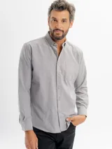 Camisa de corte regular confeccionada en tejido oxford, color azul claro. Presenta cuello con botones, cierre frontal abotonado, mangas largas con puños y un bolsillo frontal en el pecho.