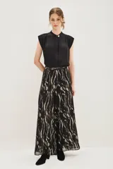 Pantalon de corte amplio y fluido con estampado de cebra en tonos negro y dorado metalizado. Presenta cintura alta y forro interior.