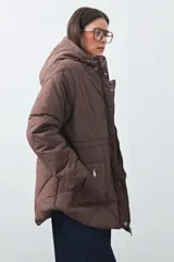 Campera matelasé color negro con capucha, cierre frontal con botones a presión y bolsillos frontales con cierre.