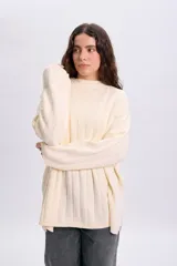 Sweater de punto liso en color crudo, de diseño oversize con cuello redondo acanalado y mangas amplias.