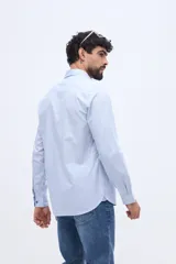 Camisa de manga larga fit semi slim color celeste, con cierre frontal de botones y cuello camisero clásico.