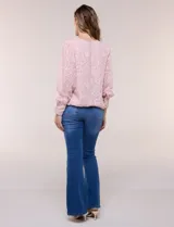 Blusa blanca de organza con textura devoré floral, silueta semiholgada y forro interno. Tiene escote bote, mangas largas abullonadas con transparencias, puños anchos con botones y ruedo elastizado.