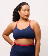 Top deportivo Get Over de corte nadador, confeccionado en microfibra azul marino con detalles en color rojo en los bordes y breteles. Presenta escote en U y copas integradas.