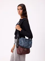 Bolso tipo morral de la marca Rusty, con diseño estampado camuflado en tonos marrones. Cuenta con correa ajustable y cierre frontal con logo de la marca.
