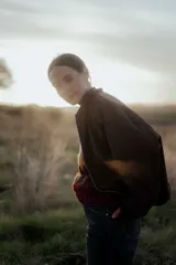 Campera tipo bomber color marrón oscuro, con cierre frontal, cuello redondo y diseño holgado.