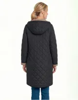 Campera reversible de corte largo con diseño capitoneado. Un lado presenta un tono verde oliva y el otro un tono negro, ambos con cierre frontal mediante botones a presión y bolsillos laterales.