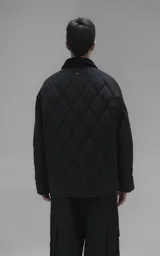 Campera oversize de microfibra opaca con diseño matelaseado de rombos. Presenta cuello de corderoy a tono, cierre frontal metálico y dos amplios bolsillos delanteros con solapa y broche snap. Interior forrado y relleno con guata térmica.