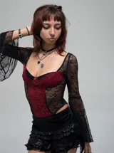 Body de encaje negro con paneles centrales en color bordó, mangas largas acampanadas y detalle de pequeña cruz metálica en el busto.