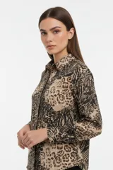 Camisa de poliéster con estampado animal print, cuello clásico, cierre frontal con botones y mangas largas con puños abotonados.