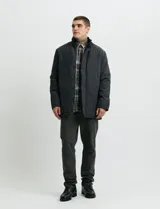 Campera de estilo Harrington en color verde oscuro, con cuello alto, cierre frontal y solapa con botones.