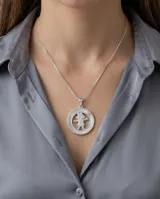 Collar de plata 925 con cadena fina y dije circular que presenta un diseño calado de una niña sobre una base de nácar.